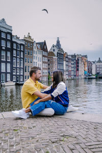 Friends sitting on water in city