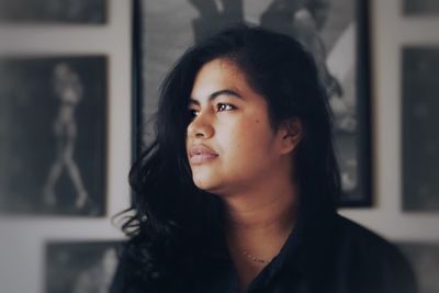 Close-up of young woman with long black hair at home