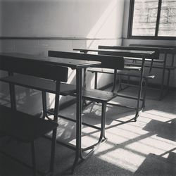 Empty chairs and table against tiled floor