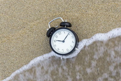 High angle view of alarm clock at sea shore