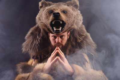 A traditional medieval bearded man dressed as an animal-bear, a symbol of power, strength and