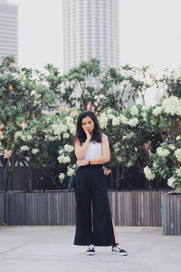 Portrait of beautiful woman against plants