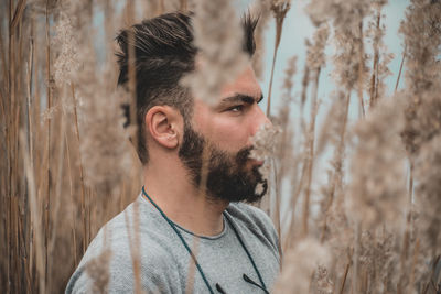 Portrait of young man looking away outdoors