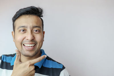 Portrait of smiling young man against white background