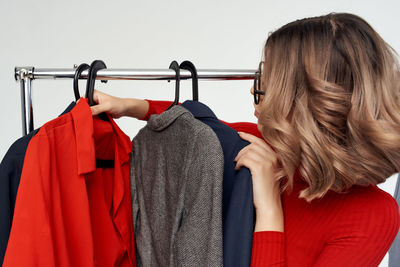 Midsection of woman holding red ball hanging on rack