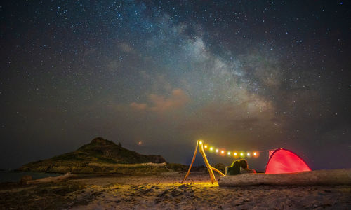 Scenic view of illuminated mountain against sky at night