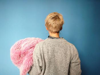 Rear view of a woman against blue background