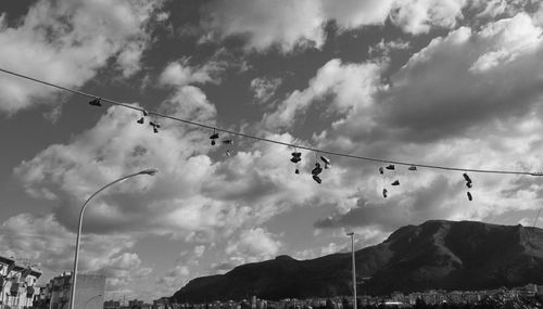Low angle view of shoes hanging from power line