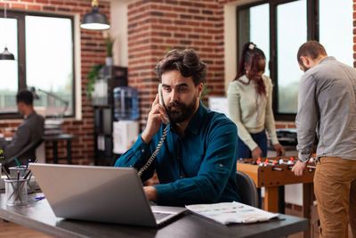 Businessman talking on phone at office