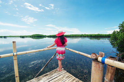 Woman looking at lake against sky