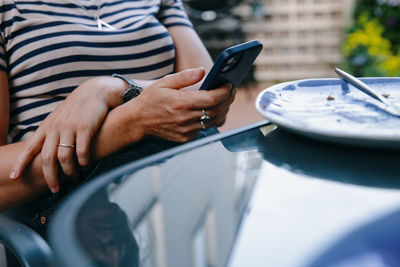 A woman checks her smartphone at the dinner table