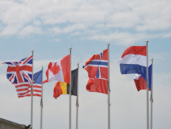 Low angle view of flags against sky