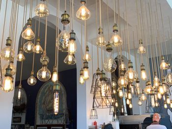 Low angle view of illuminated pendant lights hanging in building