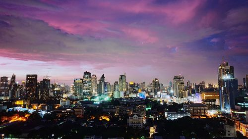 Illuminated cityscape against sky at night