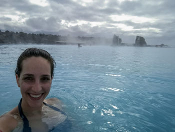 Portrait of a smiling young woman swimming in sea