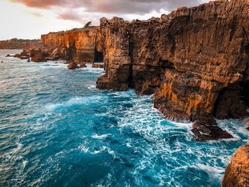 Rock formation in sea against sky