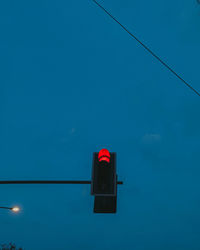 Low angle view of road signal against blue sky