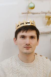 Portrait of a young guy with a crown on his head.