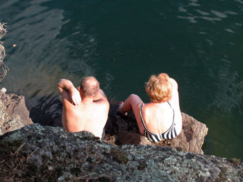 High angle view of couple sitting on rock