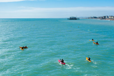 People in sea against sky