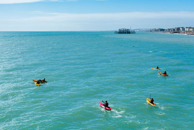 People in sea against sky