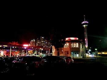 Illuminated city against sky at night