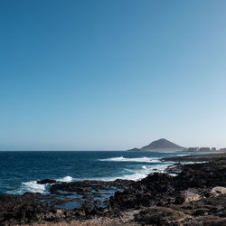 Scenic view of sea against clear blue sky