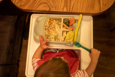 Rear view of toddler baby  holding food