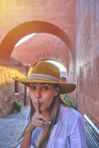 Young tourists exploring in the fountain the santa catalina monastery, arequipa. silence symbol.