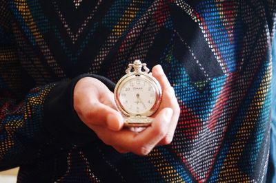 Close-up of hand holding clock