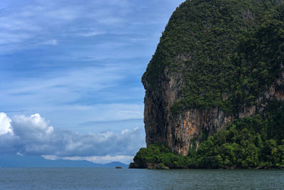 Rock formations by sea against sky