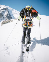 Rear view of person skiing on snow covered mountain