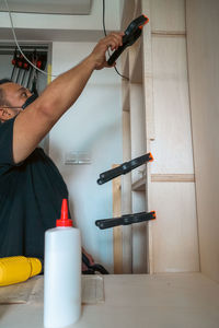 Man using clamps to hold workpiece gluing. diy project at home.