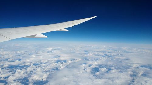 Aerial view of airplane wing against sky