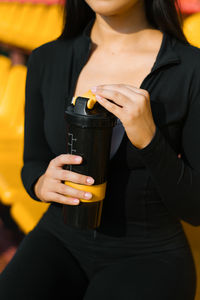Midsection of woman holding drink