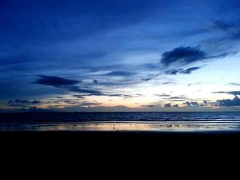 Scenic view of sea against cloudy sky at sunset