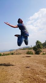 Full length of young woman jumping in mid-air