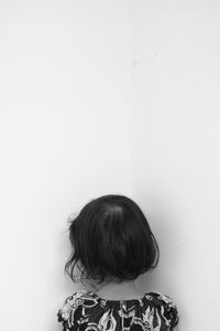 Rear view of girl standing towards wall