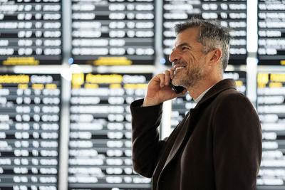 Man holding camera while standing at home