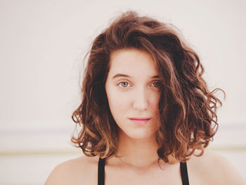 Close-up portrait of young woman meditating in yoga studio