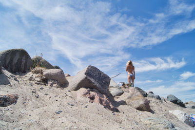 Low angle view of man on rock against sky