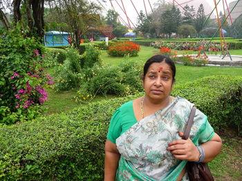 Mature woman standing by flowering plants in park