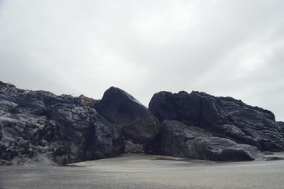 Rock formations by road against sky