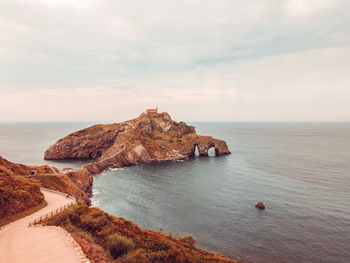 Rock formation in sea against sky