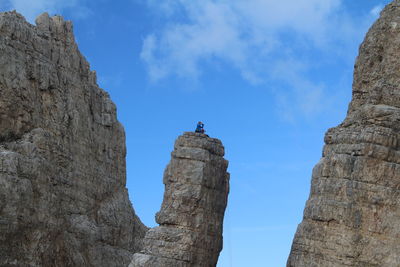 Man having a break time on top of a vertical rock on torre di pisa trail