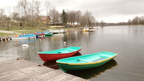 Boats moored in lake against sky