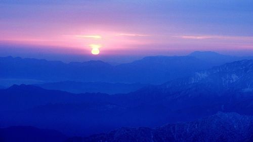 Scenic view of mountains against sky at sunset