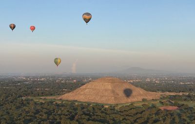 Hot air balloons flying over landscape