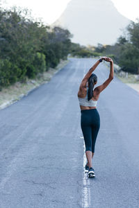 Full length of woman jumping on road