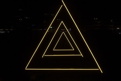 Low angle view of illuminated sign at night